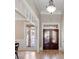 Elegant foyer showcases hardwood floors and decorative double doors, highlighted by natural light from a large window, creating a grand entry at 6191 Talmadge Run, Acworth, GA 30101