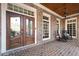 Inviting front porch with rocking chairs, brick flooring, and an ornate wood front door at 6191 Talmadge Run, Acworth, GA 30101