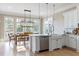 Well-lit kitchen featuring white cabinets, stainless steel appliances, and an island with a farmhouse sink at 6191 Talmadge Run, Acworth, GA 30101