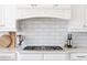 Close up of kitchen with gas cooktop, white cabinetry, and white subway tile at 6191 Talmadge Run, Acworth, GA 30101