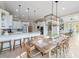 Open concept kitchen featuring white cabinetry, stainless steel appliances, and a long wooden dining table at 6191 Talmadge Run, Acworth, GA 30101