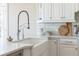 Close-up of bright kitchen showing a large farmhouse sink and white subway tile backsplash at 6191 Talmadge Run, Acworth, GA 30101