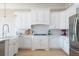 Bright kitchen features white cabinetry, stainless appliances, white subway tile backsplash, and farmhouse sink at 6191 Talmadge Run, Acworth, GA 30101