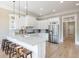 Bright kitchen with stainless steel appliances, white cabinets, marble countertops, and wooden bar stools at 6191 Talmadge Run, Acworth, GA 30101