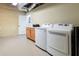 Bright laundry area with modern washer and dryer, plus storage cabinets and a view of the unfinished basement at 6191 Talmadge Run, Acworth, GA 30101