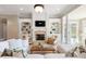 Bright living room featuring a fireplace, custom built-ins, and large windows for natural light at 6191 Talmadge Run, Acworth, GA 30101