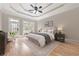 Serene bedroom with tray ceilings, a cozy sitting area, and a door leading to the outdoor deck at 6191 Talmadge Run, Acworth, GA 30101