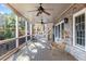 Spacious covered porch with ceiling fans and a seating area overlooking the treeline at 6191 Talmadge Run, Acworth, GA 30101