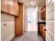 Functional laundry room with wood cabinets and tiled floor at 211 Iroquois Ct, Covington, GA 30014