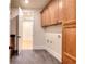 Well-lit laundry room with built-in cabinets and tiled floors at 211 Iroquois Ct, Covington, GA 30014