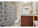 Well-lit bathroom featuring a decorative shower curtain, wooden vanity, and modern fixtures at 361 17Th Nw St # 2208, Atlanta, GA 30363