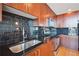 Close up of a modern kitchen featuring stainless steel appliances, black countertops, and dark tile backsplash at 361 17Th Nw St # 2208, Atlanta, GA 30363