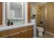 Well-lit bathroom featuring a glass bowl sink, tiled shower, and wood cabinets at 4706 Warrior Se Way, Mableton, GA 30126