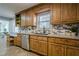 Charming kitchen boasting wood cabinetry, stainless steel dishwasher, and decorative backsplash at 4706 Warrior Se Way, Mableton, GA 30126