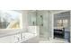 Bathroom showcases a soaking tub, separate glass shower, and window at 1560 Tapestry Rdg, Lawrenceville, GA 30045
