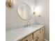 Bathroom featuring a sleek vanity with marble countertop, stylish lighting fixtures, and a round mirror at 1560 Tapestry Rdg, Lawrenceville, GA 30045