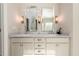Bright bathroom featuring dual sinks, marble countertop, and elegant lighting at 1560 Tapestry Rdg, Lawrenceville, GA 30045
