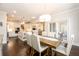 Bright dining area with a wooden table and white chairs next to an open kitchen with white cabinets and a large island at 1560 Tapestry Rdg, Lawrenceville, GA 30045
