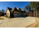 Long driveway leading to a three-car garage, surrounded by mature trees and landscaping at 1560 Tapestry Rdg, Lawrenceville, GA 30045