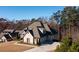Home exterior showcasing the brick facade, side-entry garage, and mature trees in the background at 1560 Tapestry Rdg, Lawrenceville, GA 30045