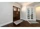 Foyer featuring hardwood floors, a decorative rug, and a striking double-door entry leading to a formal space at 1560 Tapestry Rdg, Lawrenceville, GA 30045