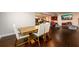 Open-concept living room with wood floors, featuring a dining table and a TV for entertainment and relaxation at 1560 Tapestry Rdg, Lawrenceville, GA 30045