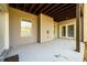 Covered concrete patio featuring neutral colored siding and a view of the wooded yard at 1560 Tapestry Rdg, Lawrenceville, GA 30045