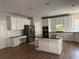 Spacious kitchen with an island, white cabinets, stainless steel appliances, and granite countertops at 1074 Bradshaw Estates Dr, Canton, GA 30115