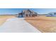 Beautiful modern farmhouse with gray siding, wood accents, and a large driveway on a sunny day at 1422 Alcovy Station Rd, Covington, GA 30014