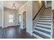 Inviting foyer features dark wood-look floors, staircase with dark wood accents, and entry to other rooms at 1422 Alcovy Station Rd, Covington, GA 30014