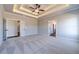 Bright main bedroom with carpet, fan, recessed ceiling, and doors to closets at 1422 Alcovy Station Rd, Covington, GA 30014