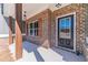 Inviting front porch with brick columns, wooden accents, and a stylish black front door at 1434 Alcovy Station Rd, Covington, GA 30014