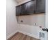 Compact laundry room with overhead cabinets and convenient utility connections at 1452 Alcovy Station Rd, Covington, GA 30014