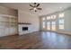 Bright living room featuring a ceiling fan, brick fireplace, wood floors, and double doors leading outside at 1452 Alcovy Station Rd, Covington, GA 30014