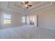 Spacious main bedroom featuring a tray ceiling, ceiling fan, and large windows at 1452 Alcovy Station Rd, Covington, GA 30014