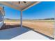 Back porch looking out on a large, grassy backyard and wooded view on a sunny day at 1452 Alcovy Station Rd, Covington, GA 30014