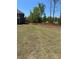 View of backyard bordering wooded area/golf course under a clear sky at 5000 Fairview Cir, Villa Rica, GA 30180