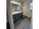 Bathroom with double sink vanity, wood-look floors, and ample lighting at 5000 Fairview Cir, Villa Rica, GA 30180