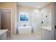 Elegant bathroom featuring a freestanding tub, glass-enclosed shower, and a bright window at 37 Harmony Ridge Dr, Temple, GA 30179