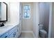 Bright bathroom featuring a white vanity, linen cabinet, and a separate toilet room at 37 Harmony Ridge Dr, Temple, GA 30179