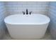 Close-up of a freestanding white bathtub with sleek black fixtures and white subway tile surround at 37 Harmony Ridge Dr, Temple, GA 30179