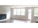 Bright living room featuring three large windows, a fireplace, and hardwood floors, and a view into the kitchen at 1059 Crest Mill Dr, Marietta, GA 30008
