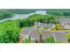 Aerial view of homes nestled amongst trees near a lake, showcasing the neighborhood's scenic setting at 413 Solace Pl, Canton, GA 30114