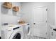 Efficient laundry room with modern appliances, storage shelves, and a countertop at 1693 Juniper Berry Way, Loganville, GA 30052