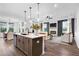 Open-concept living space showcasing a kitchen island, modern lighting, and a cozy fireplace at 1693 Juniper Berry Way, Loganville, GA 30052