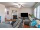 Open living area with hardwood floors, sectional sofa, fireplace, and large TV at 2354 Attewood Dr, Buford, GA 30519