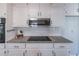 Modern kitchen features granite countertops, a sleek cooktop, and white cabinetry at 296 Ridgedale Way, Lawrenceville, GA 30044