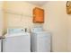 Laundry room with washer, dryer, overhead cabinet, and wire shelving at 1967 Woodland Park Cir, Lawrenceville, GA 30043