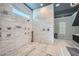 Spa-like bathroom featuring marble walls, dual shower heads, and a window for natural light at 2015 Shaudi Ln, Atlanta, GA 30345