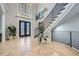 Stunning foyer with herringbone wood floors, black railing staircase, and transom window over front door at 2015 Shaudi Ln, Atlanta, GA 30345